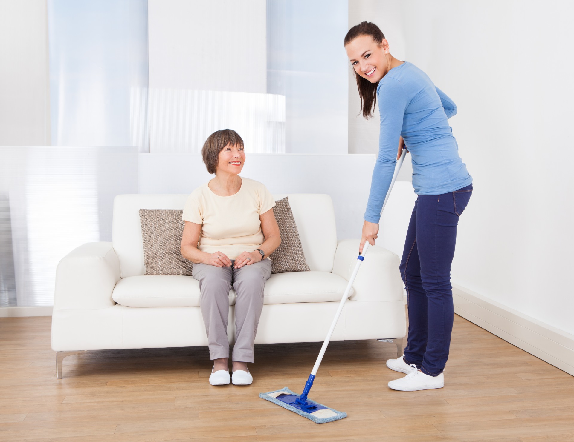 Cleaning lady mopping floor while someone watches